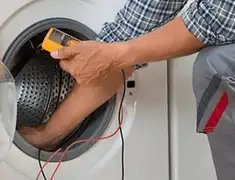 Washing machine repair technician testing a front-load washer with diagnostic tools in Boston, MA