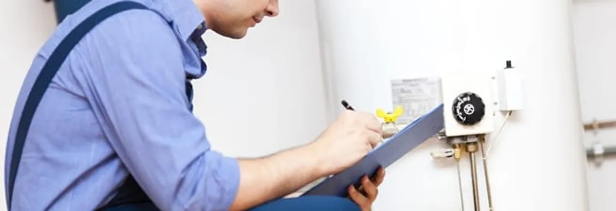 Water heater repair technician inspecting the unit and recording service notes in Boston, MA